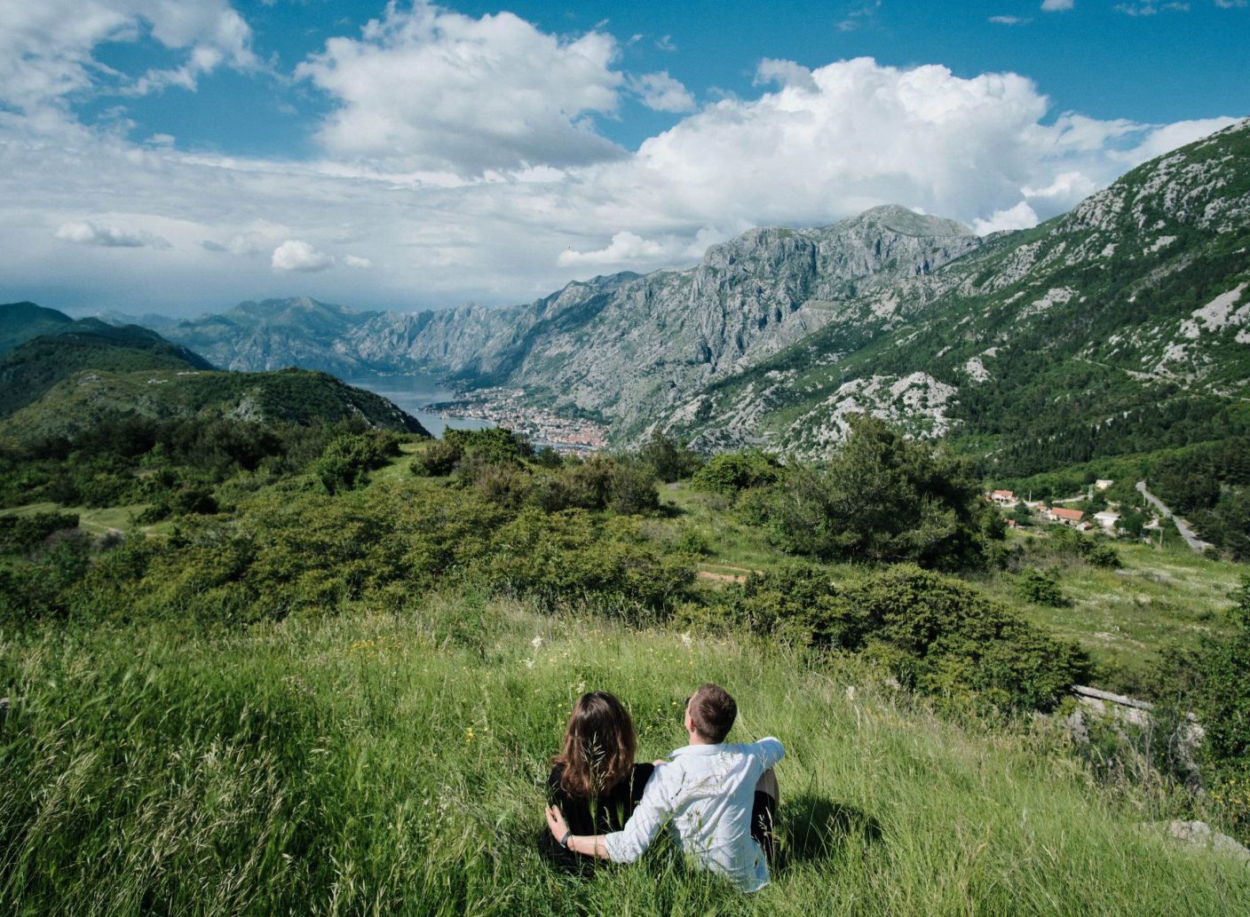 back-view-romantic-couple-enjoy-view-mountains-sunny-day-montenegro-min